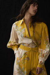 Close-up of a woman's face and upper body in a floral print linen shirt.