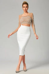 Woman wearing a sheer embellished crop top and white pencil skirt, slightly angled view