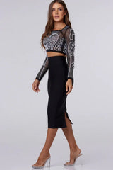 Woman in a black embellished crop top and black pencil skirt, side view
