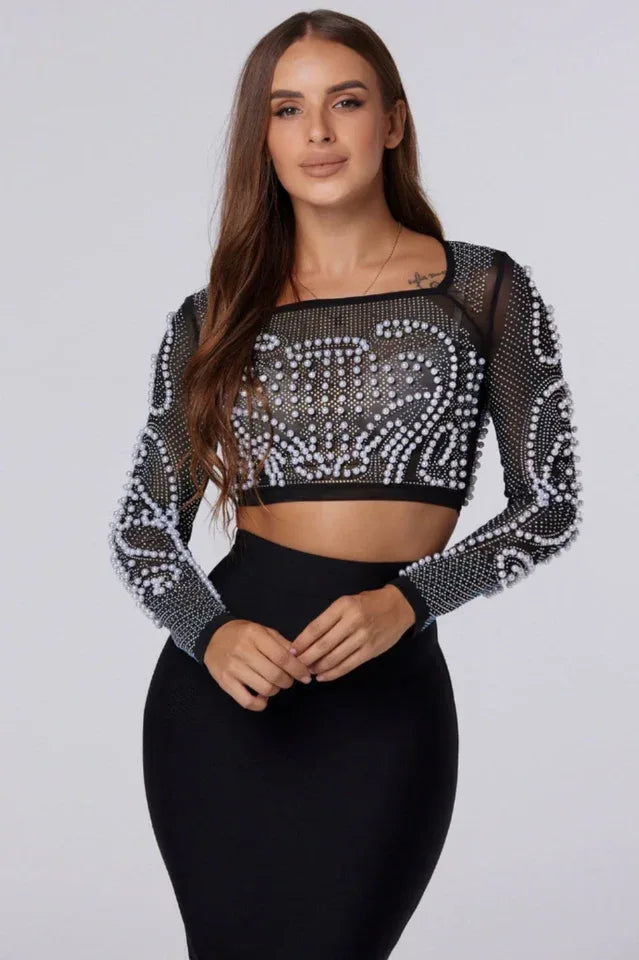 Close-up of woman wearing a black embellished crop top and black pencil skirt