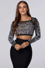 Close-up of woman wearing a black embellished crop top and black pencil skirt