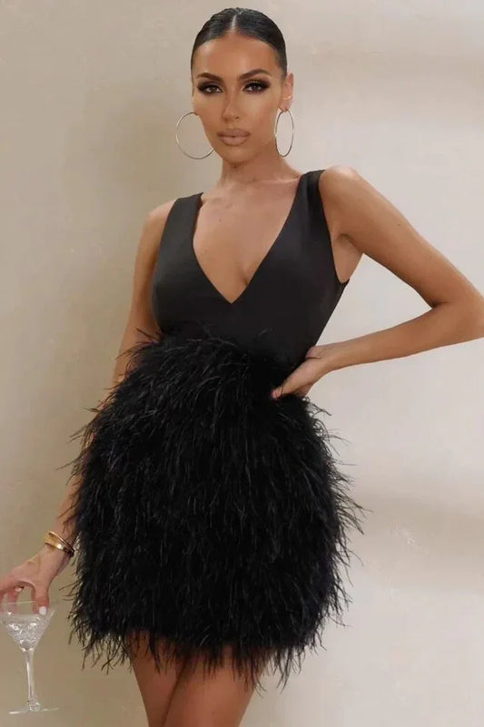Woman wearing a black sleeveless mini dress with a deep V-neckline and a full feather skirt, holding a cocktail glass.