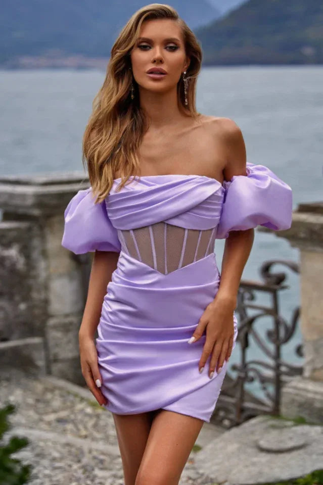 Woman wearing a lavender off-the-shoulder ruched mini dress with puff sleeves and a corset-style bodice.
