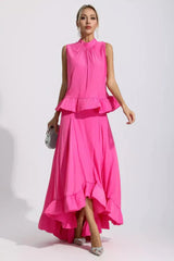 Woman in a bright pink two-piece set, holding a silver clutch.