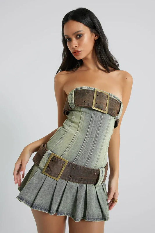 Woman wearing a strapless denim mini dress with a pleated skirt and buckle detailing.