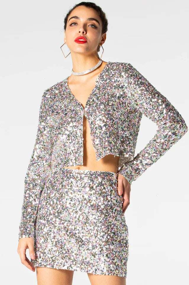 Close-up of a woman wearing a sequined cropped jacket and matching mini skirt