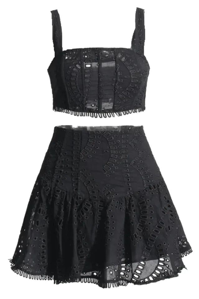 Black embroidered eyelet crop top and flared skirt set laid flat.