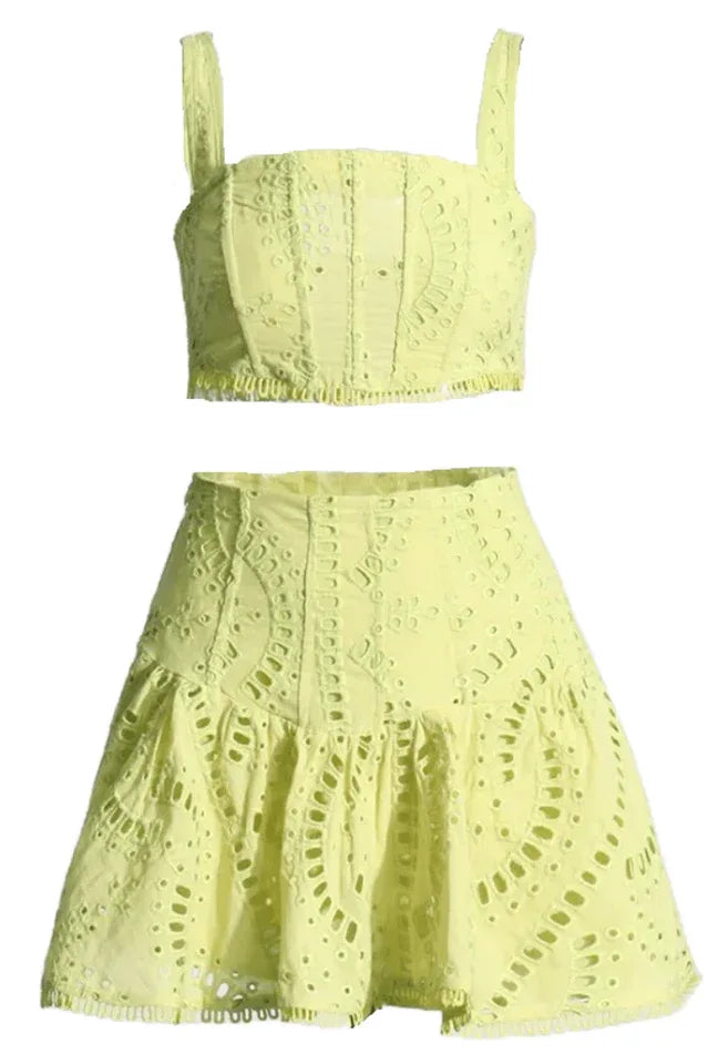 Yellow embroidered eyelet crop top and flared skirt set laid flat.