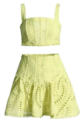 Yellow embroidered eyelet crop top and flared skirt set laid flat.
