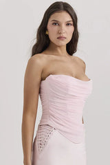 side view of a woman in a light pink strapless ruched corset top