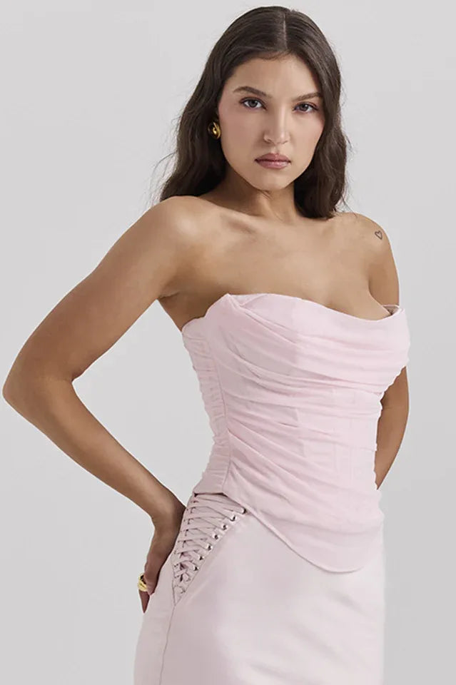 back view of a woman wearing a light pink strapless ruched corset top