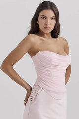 back view of a woman wearing a light pink strapless ruched corset top