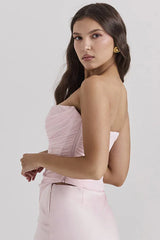 three-quarter view of a woman in a light pink strapless ruched corset top