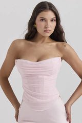 woman wearing a light pink strapless ruched corset top with lace-up side detail