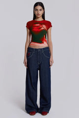 Woman wearing dark wash wide leg jeans and a red and green graphic t-shirt