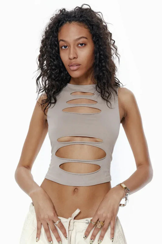 Model wearing a taupe sleeveless cropped top with horizontal cut-outs on the front, paired with light-colored cargo pants.