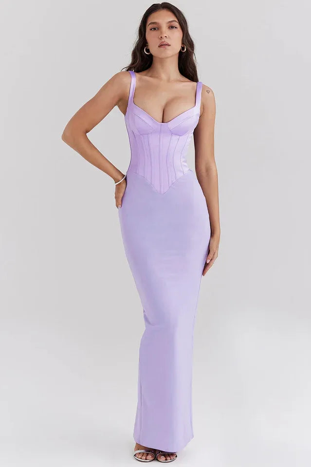 Woman wearing a long lavender corset dress with spaghetti straps and a square neckline, standing against a white background.