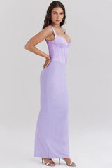 Side view of a woman wearing a long lavender corset dress with a square neckline and spaghetti straps.