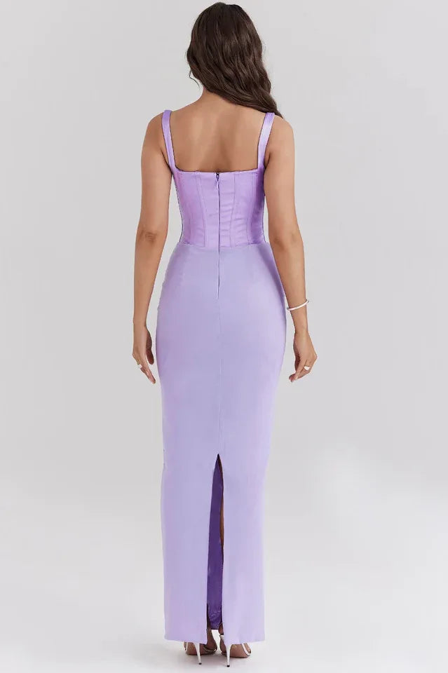 Back view of a woman wearing a long lavender corset dress with a square neckline and spaghetti straps.