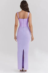 Back view of a woman wearing a long lavender corset dress with a square neckline and spaghetti straps.