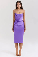 Woman wearing a strapless purple satin midi dress with a cowl neckline and ruched detailing.