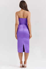 Back view of a woman wearing a strapless purple satin midi dress with a cowl neckline and ruched detailing.