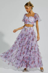 Woman twirling in a flowing floral print tiered skirt.