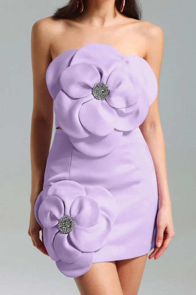 Front view of a lavender strapless mini dress with two large floral appliques, one on the bust and one on the hip, each with a jeweled center.