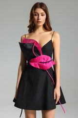 Black mini dress with vibrant pink floral applique detail and thin spaghetti straps, front view