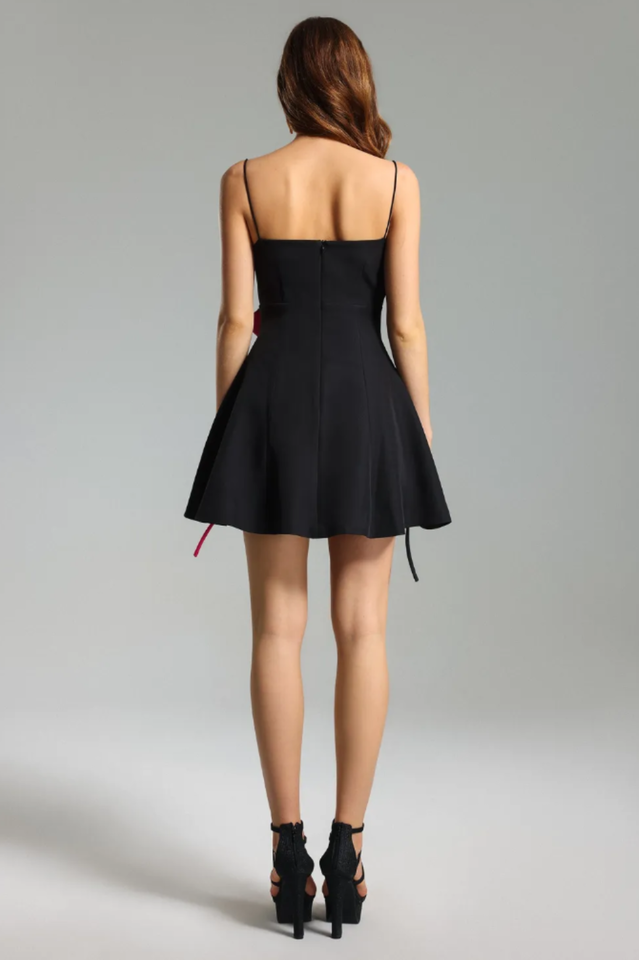 Back view of a black mini dress with thin spaghetti straps and a flared skirt