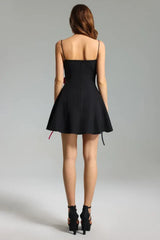 Back view of a black mini dress with thin spaghetti straps and a flared skirt
