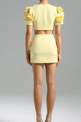 Back view of a woman in a yellow floral crop top and mini skirt