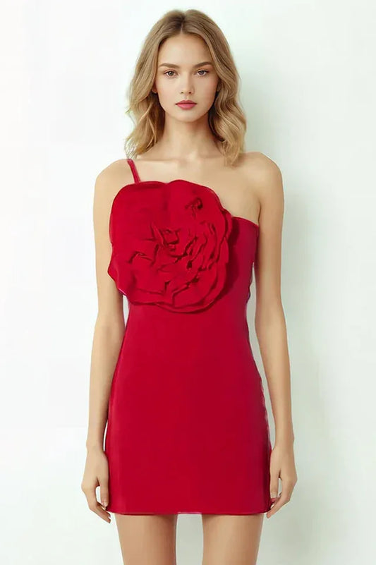 Red one-shoulder mini dress with large floral applique on the bust, worn by a woman with blonde hair.