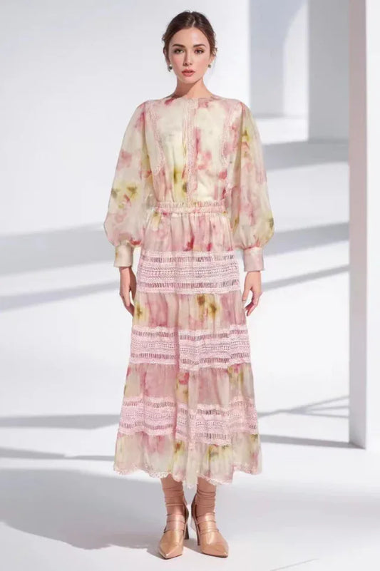 Woman wearing a pink floral print maxi dress with puff sleeves and lace trim
