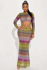 Woman wearing a long sleeve crop top and maxi skirt with abstract print and cut-out details
