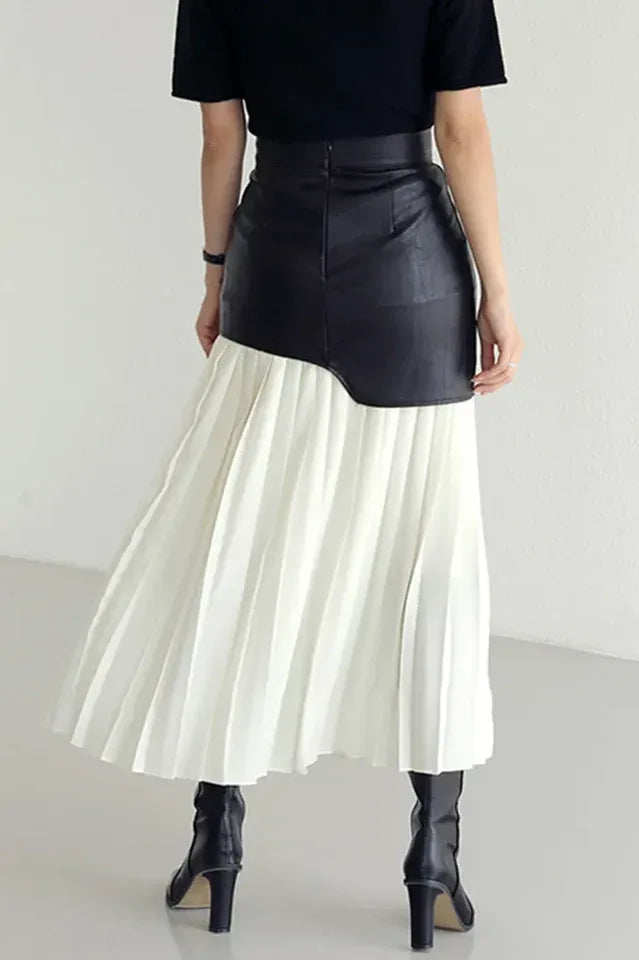 Back view of a black and white paneled pleated skirt with black boots