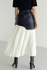 Back view of a black and white paneled pleated skirt with black boots