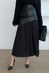 Model wearing a black paneled pleated skirt with black sweater and black heels