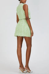 Rear view of a model in a lime green textured tweed crop top and mini skirt set with embellished collar.