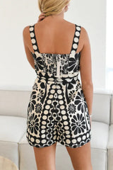 Back view of a woman in a black and white printed romper with a smocked back.