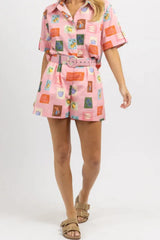 Full body shot of a woman in a pink printed linen blend matching set with short sleeves and high-waisted shorts, accessorized with tan sandals.