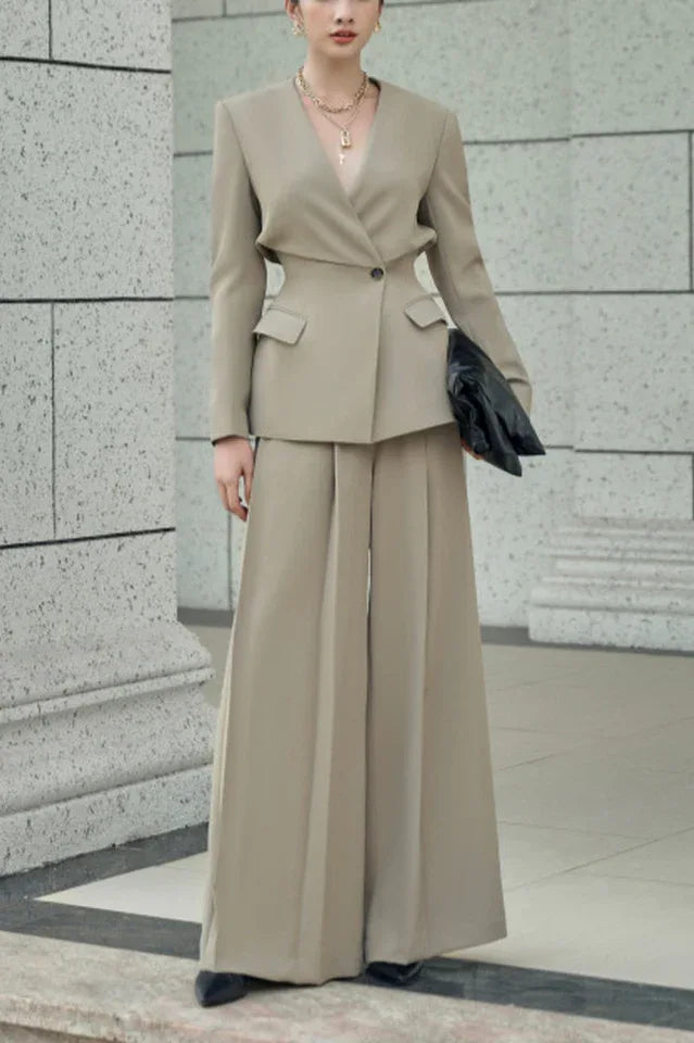 Woman wearing a beige pantsuit with wide-leg pants and a lapel blazer.