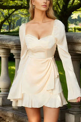 Close-up of the cream satin dress, highlighting the sweetheart neckline and wrap skirt.