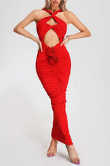 woman wearing a red halter neck maxi dress with a cutout and rose detail