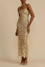 Woman wearing a gold floral lace maxi dress with spaghetti straps
