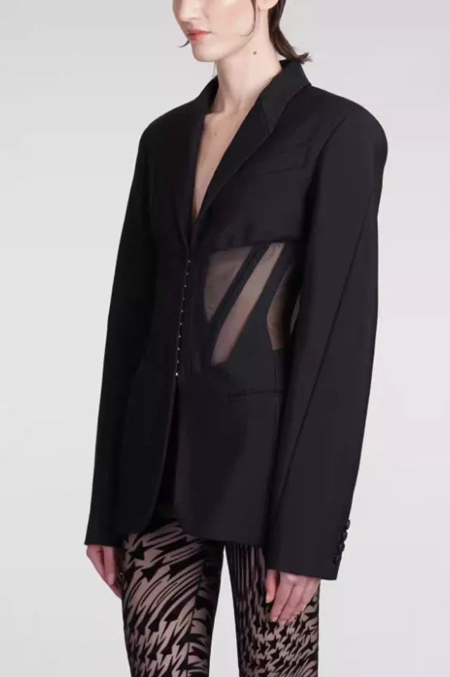 Side view of black fitted blazer with sheer corset detail