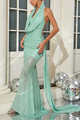 Detail of the back of a mint green sequined halter neck mermaid gown with an open back and train