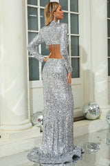 Back view of a woman in a silver sequin two-piece evening gown with a crop jacket and mermaid skirt.