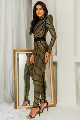Side view of a woman in a black and gold rhinestone embellished two-piece set.