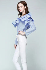 Side view of a woman wearing a blue and white striped off-the-shoulder ruffled blouse and white pants.